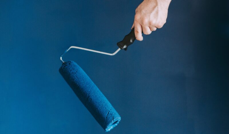 closeup-shot-female-using-paint-rollers-with-color-blue