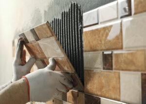 laying-ceramic-tiles-tiler-placing-ceramic-wall-tile-position-adhesive