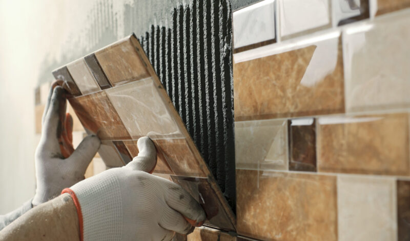 laying-ceramic-tiles-tiler-placing-ceramic-wall-tile-position-adhesive