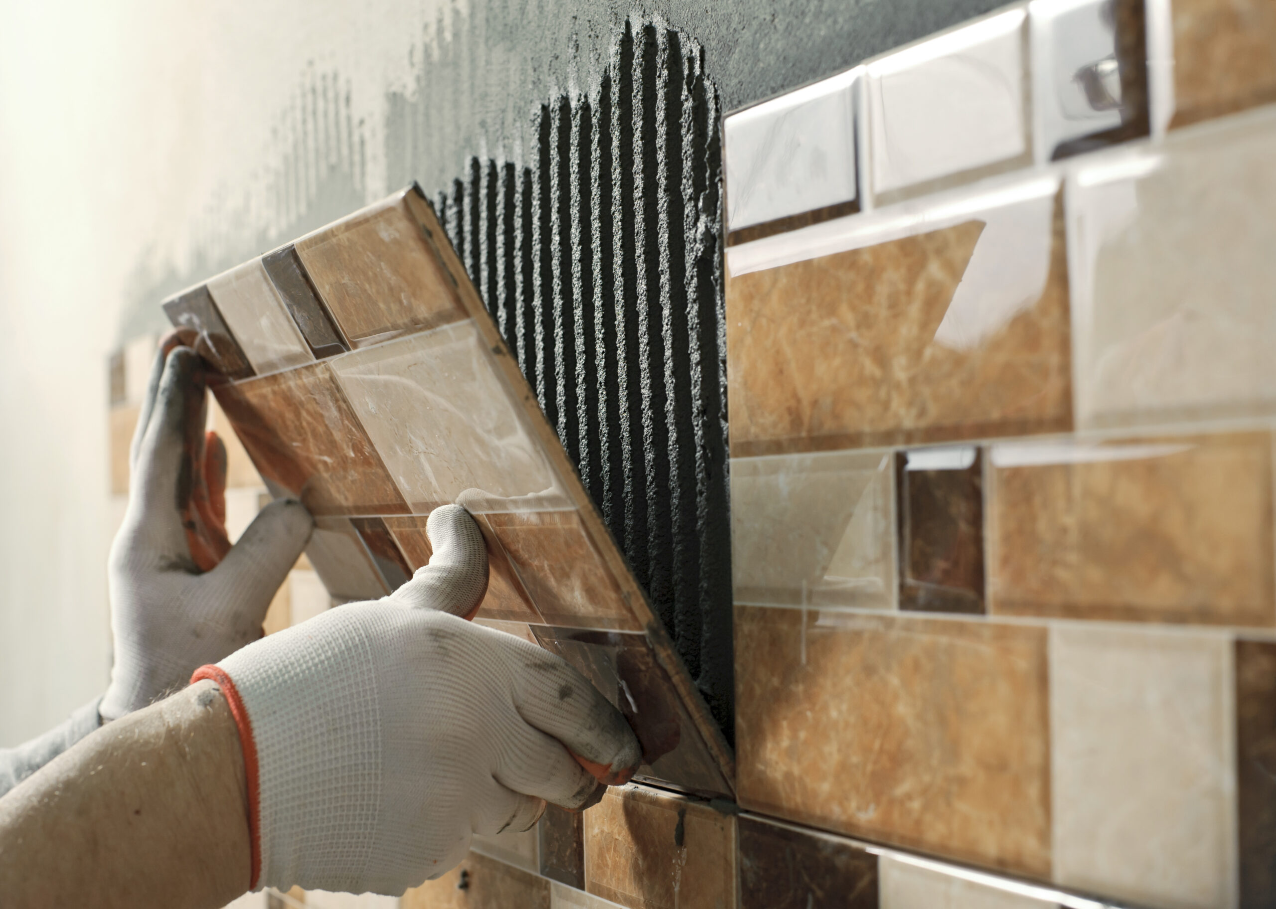 laying-ceramic-tiles-tiler-placing-ceramic-wall-tile-position-adhesive