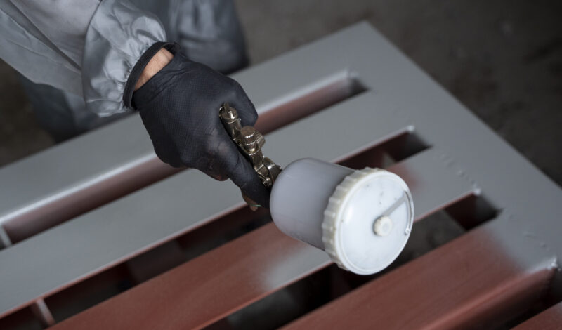 high-angle-worker-spraying-powder-paint-from-gun